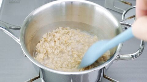 Stirring oatmeal in a pot.