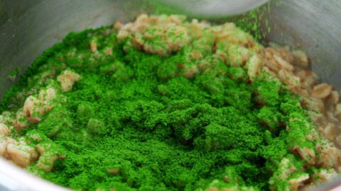 Sifting matcha powder into a pot of cooked oatmeal.