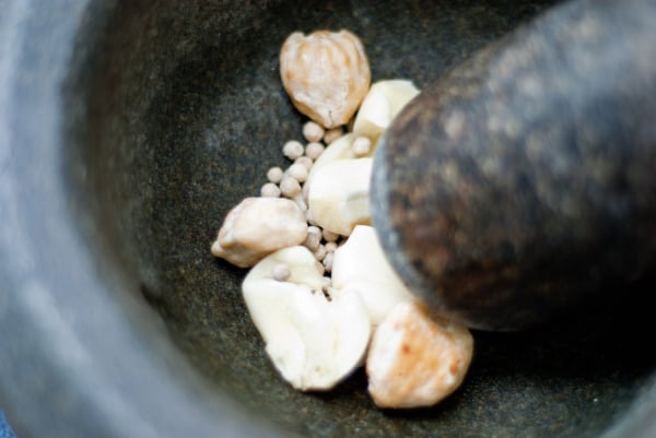 crushing the garlic, candlenuts, and white pepper