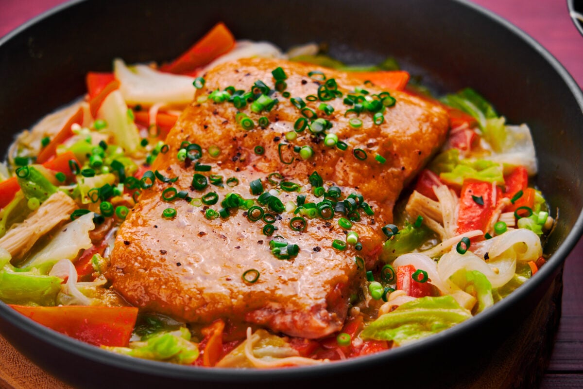 Miso butter glazed salmon steamed on a bed of sweet vegetables.