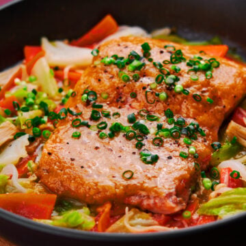 Miso butter glazed salmon steamed on a bed of sweet vegetables.