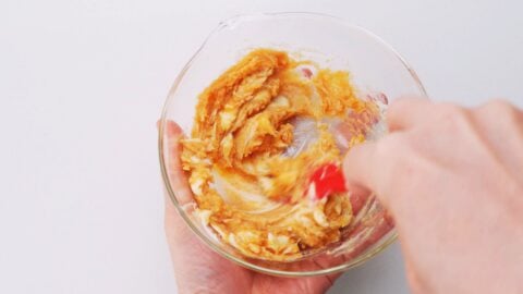 Mixing miso and butter together in a glass bowl.