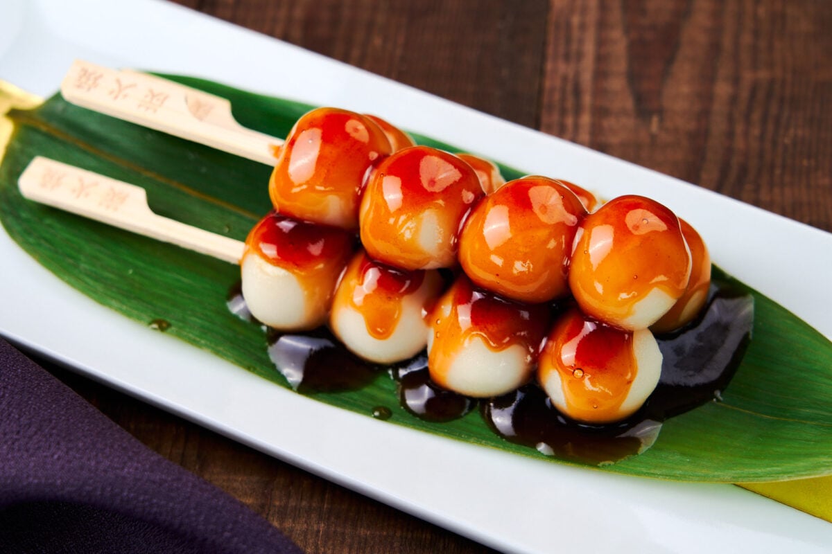 MItarashi Dango are a traditional Japanese snack made by glazing grilled rice dumplings with a savory sweet sauce.