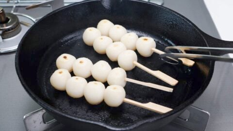 Charred Mitarashi Dango in a cast iron skillet.