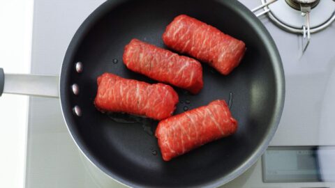 Pan-frying meat wrapped onigiri.