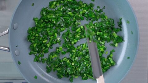 Sauteed Chinese Chives in a frying pan for making Niratama.