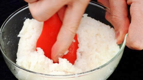 Mashing mochi rice with a spatula.