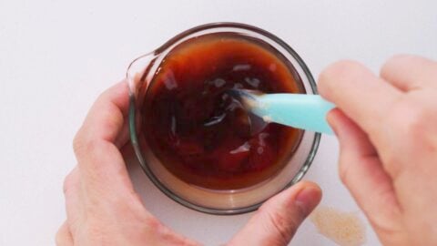 Mixing sauce for taco rice in a glass bowl.