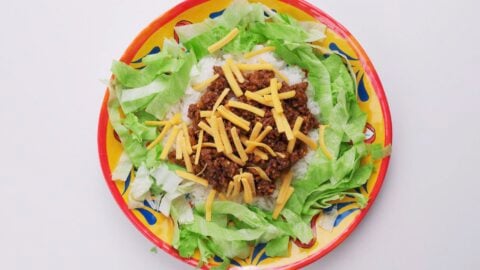 Rice and lettuce with taco meat and cheese.