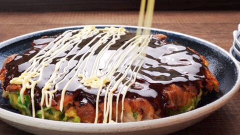 Japanese savory pancake glazed with Okonomiyaki sauce and drizzled with mayonnaise.