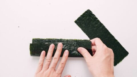 Cutting nori into strips for wrapping rice balls.