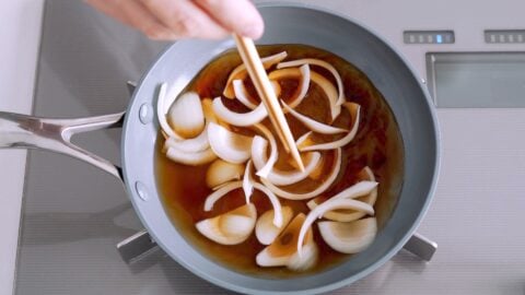 Onions cooking in dashi broth for making Oyakodon