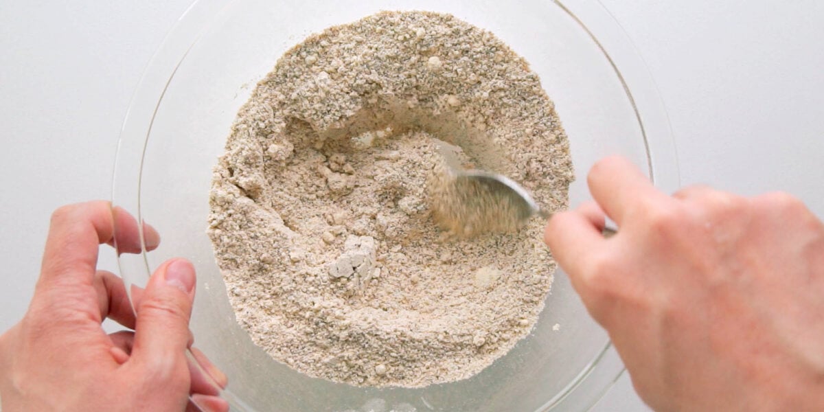 Mixing dry ingredients together in a glass bowl for Peanut Butter Cookies.