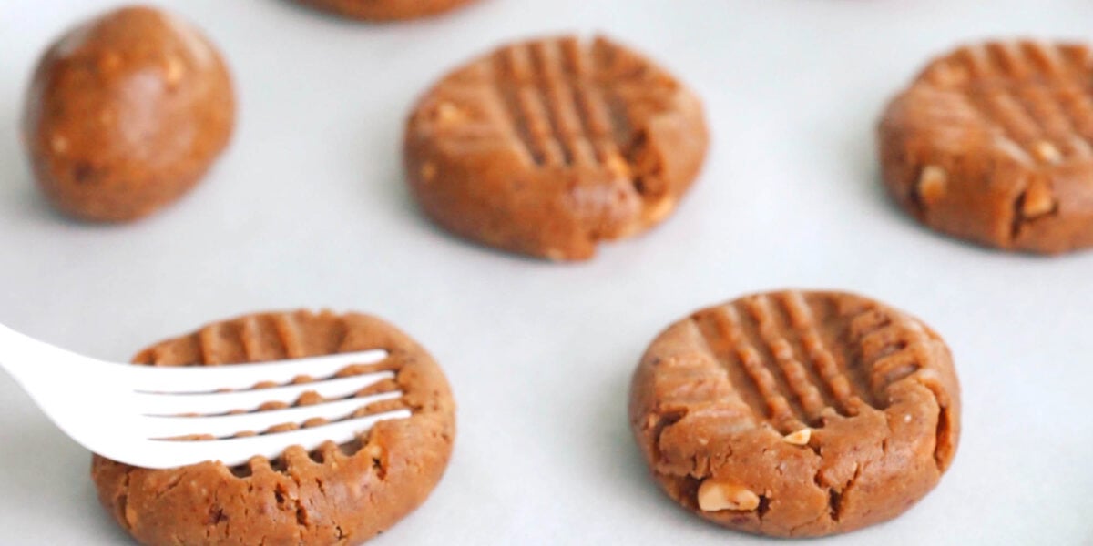 Flattening Peanut Butter Cookie dough with a fork.