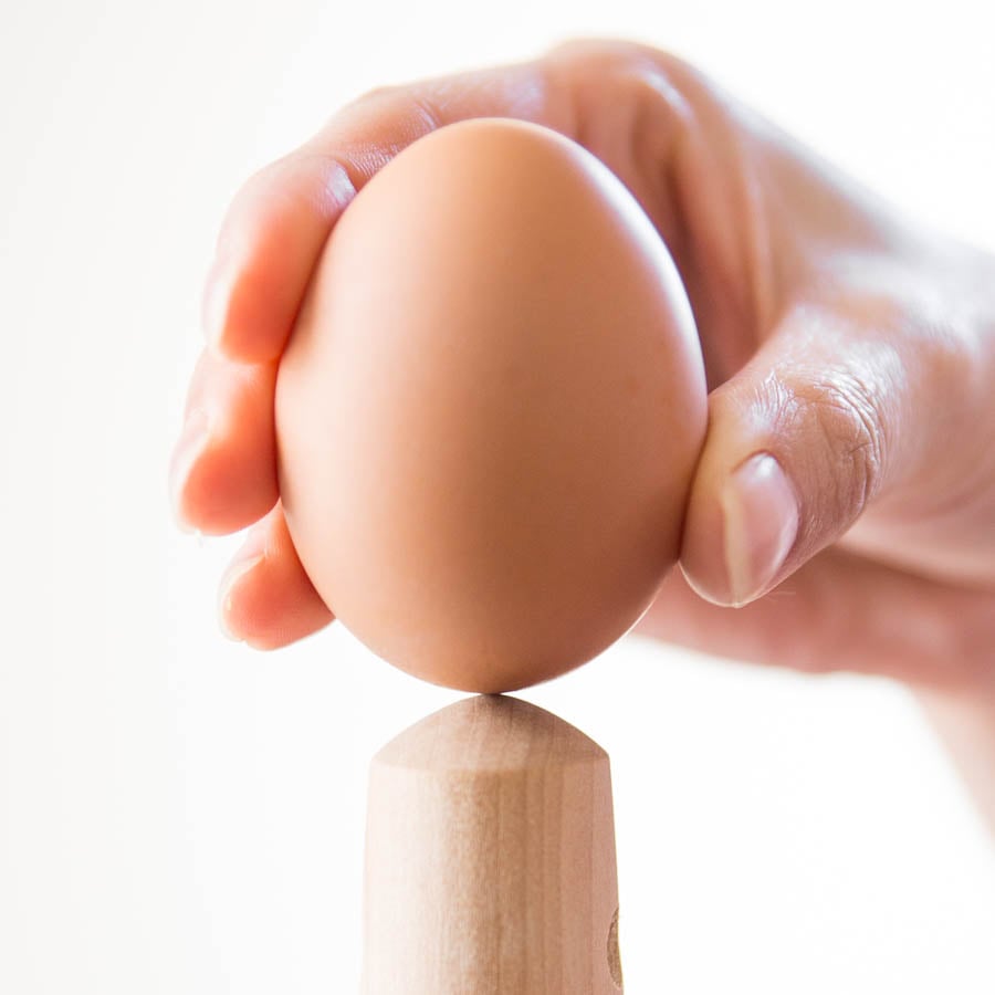 Crack the blunt bottom of the egg on a curved object before boiling.