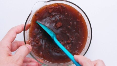 Mixing ingredients together for curry sauce in a glass bowl.