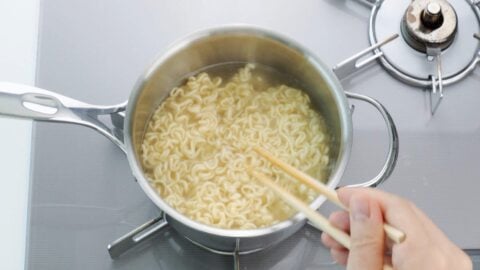 Boiling instant ramen noodles.