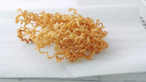 Fried ramen noodles draining on paper towels.