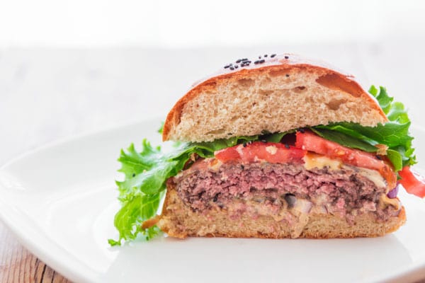 Cross section of a hamburger with a perfectly pink medium rare middle.