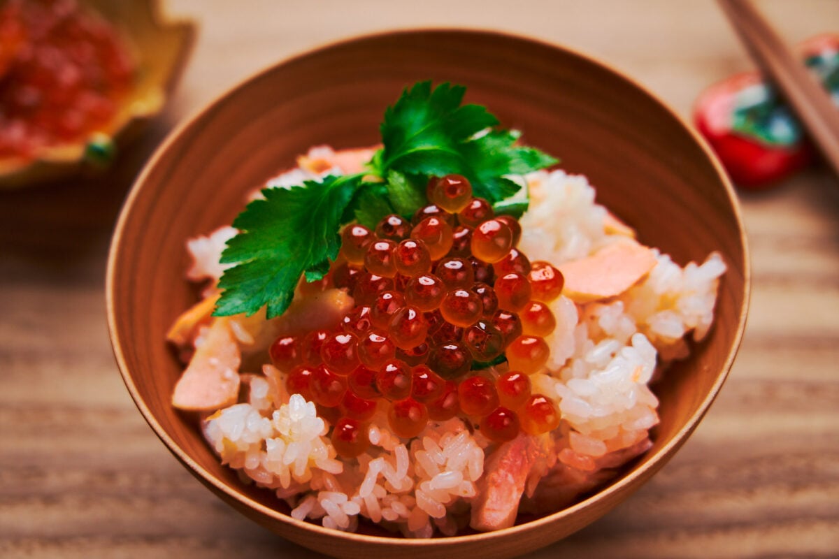 Salmon Takikomi Gohan topped with mitsuba and ikura. A popular fall meal in Japan.