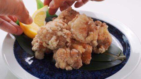 Plating Japanese fried chicken with lemon wedges.