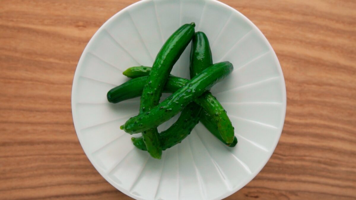 A plate of cucumber tsukemono, or Japanese pickles made by soaking whole cucumbers in a salt brine.