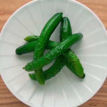 A plate of cucumber tsukemono, or Japanese pickles made by soaking whole cucumbers in a salt brine.