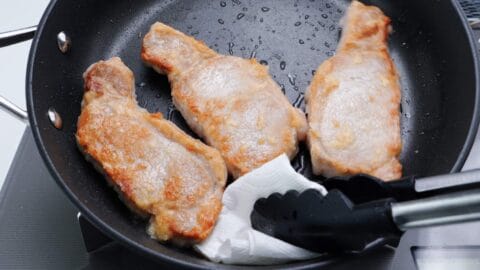 Soaking up excess oil in the pan after frying Japanese pork chops.