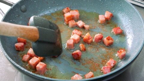 Frying Tasso ham in a frying pan.