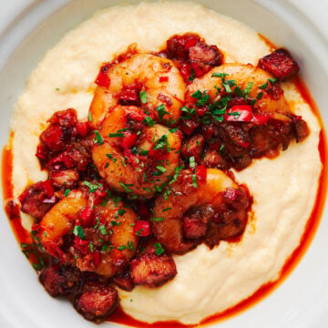 The best shrimp and grits recipe, made with smoky cajun shrimp, served on a bowl of cheddar cheese grits.