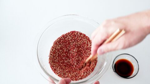 Mixing chili flakes, sesame seeds and spices together in a glass bowl for making chili oil