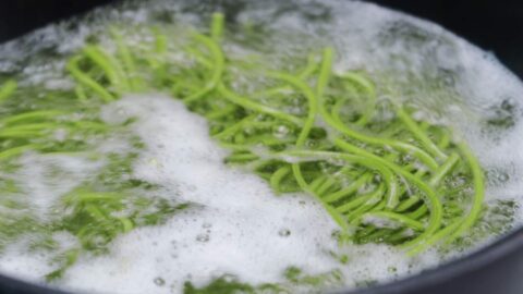 Matcha soba noodles in boiling water.