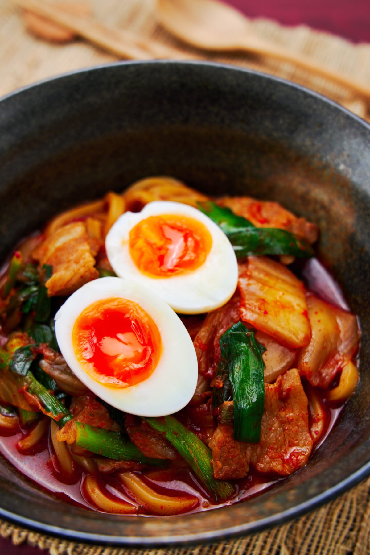 Thick chewy udon noodles in a spicy pork and kimchi broth topped with a soft boiled egg with a molten yolk.