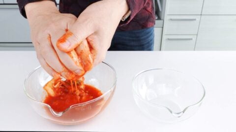 Squeezing kimchi juice from kimchi.