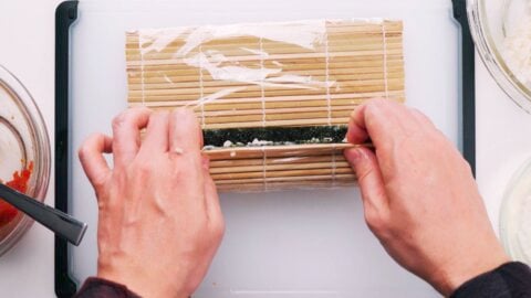 Rolling hosomaki with a sushi mat.