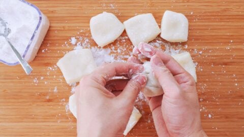 Add the strawberry with the tip facing down and pull the edges of the mochi up and over the filling.