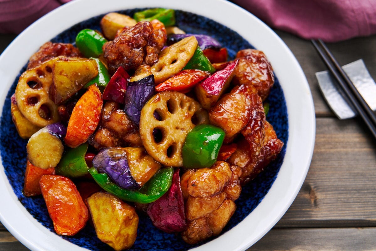 Homemade sweet and sour chicken with loads of colorful vegetables like eggplant, carrots and peppers.