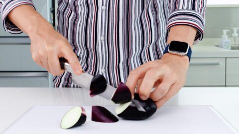 Slicing eggplant into an oblique cut.