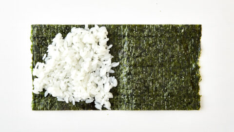 Spread the rice out into a triangle over half the nori.