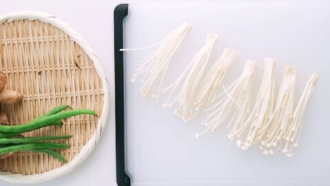 Enoki mushrooms separated into clusters for tempura.