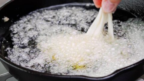 Adding Enoki tempura to oil.