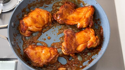 Chicken thighs glazed with easy teriyaki sauce in a frying pan.