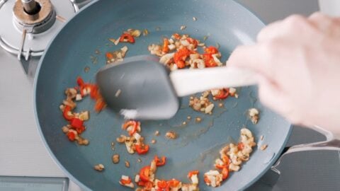 Sautéing garlic and chili peppers for making Thai Basil Chicken.