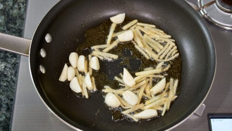 Start your Three Cup Chicken by frying the garlic and ginger in sesame oil.