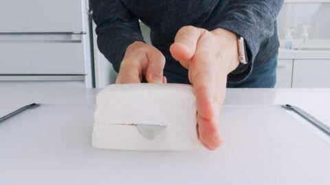 Slicing block of tofu into steaks.