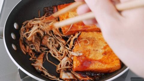 Coating mushrooms with steak sauce.