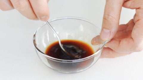 Mixing teriyaki sauce in a glass bowl.