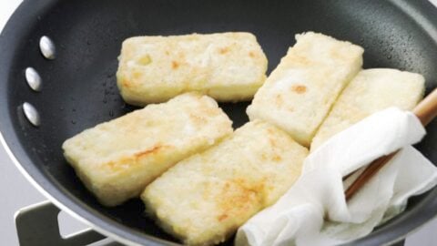 Crispy browned tofu in a frying pan.