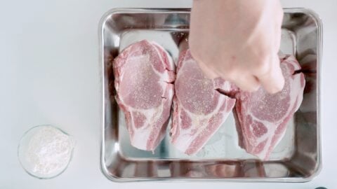 Sprinkling pork cutlets with salt and pepper.