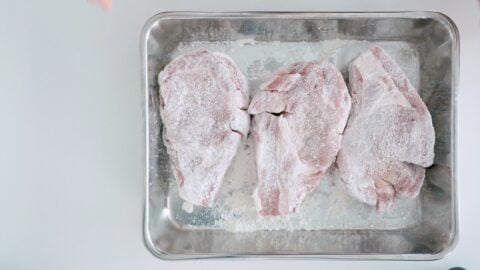 Dusting pork rib-chops with flour